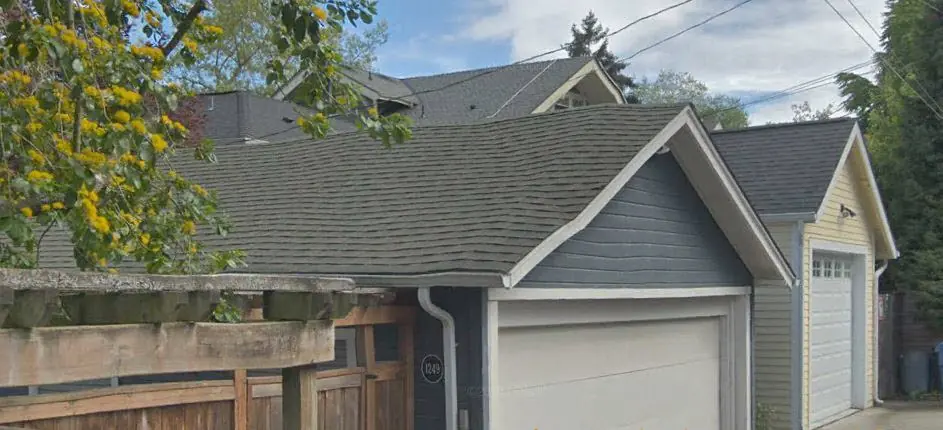 Composition shingle roof on a Seattle home with attached garage, viewed from the alley